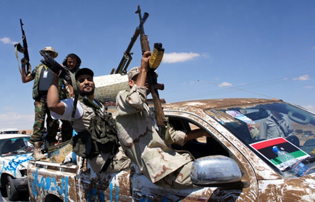 Rząd w Trypolisie najwyraźniej nie sprawuje efektywnej kontroli nad sytuacją w kraju, gdzie wciąż działa szereg ugrupowań zbrojnych. Na zdjęciu członkowie libijskich milicji podczas walk w 2011 roku. Fot. Elizabeth Arrott/Voice of America/Wikimedia Commons.