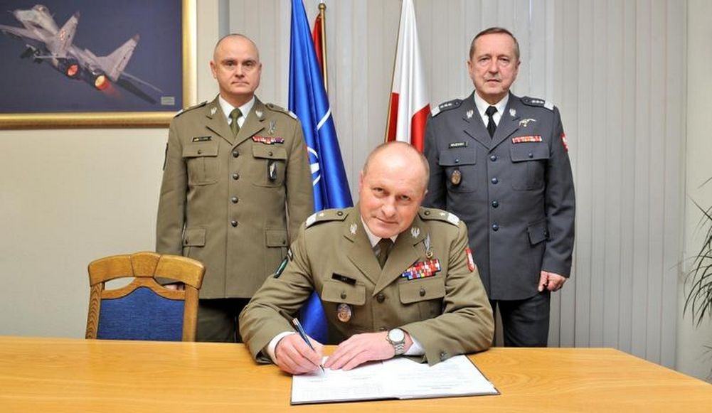 Gen. Jerzy Gut podpisujący dokument przekazania DSS w obecności gen. Piotra Patalonga i gen.Lecha Majewskiego. - fot. MON