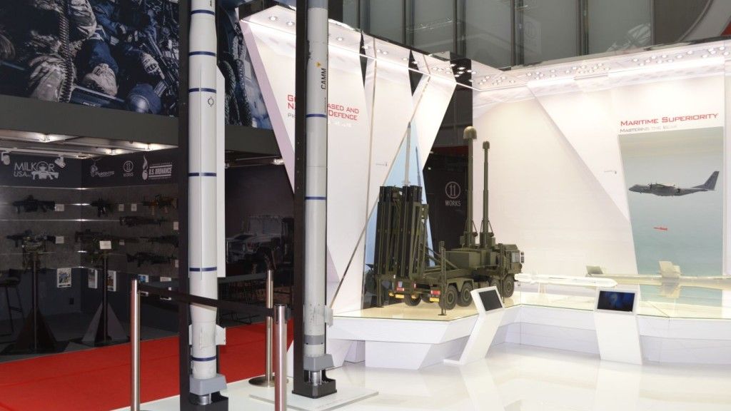 Stoisko MBDA na MSPO 2018 z widocznymi od lewej makietami rakiet CAMM-ER i CAMM oraz wyrzutni mobilnej na pojeździe kołowym. Fot. M.Dura