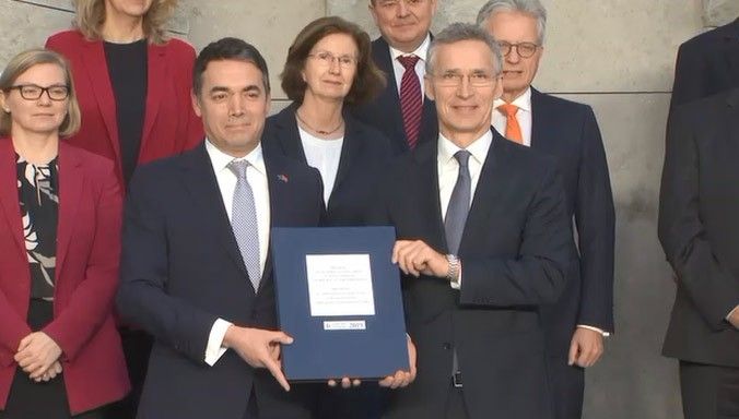 Sekretarz generalny NATO Jens Stoltenberg (z prawej) i minister spraw zagranicznych Macedonii Nikola Dimitrov prezentują protokół akcesyjny. Fot. NATO