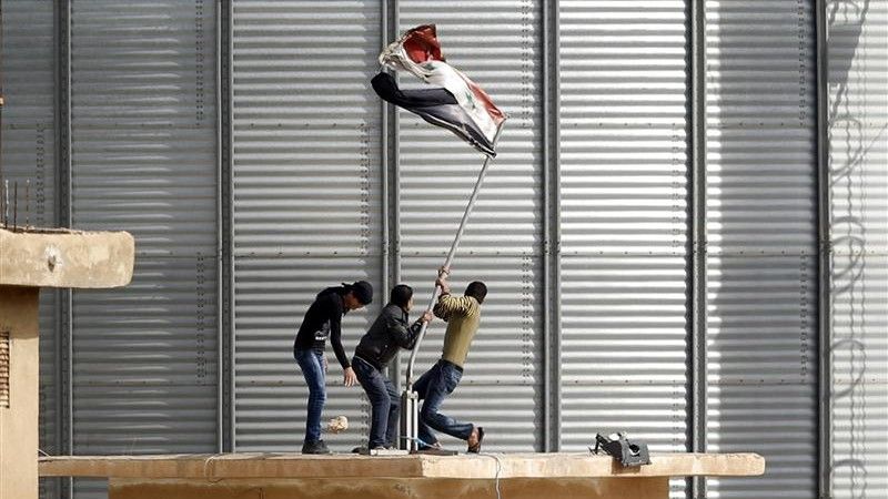 Powstańcy zdejmujący flagę Syrii z posterunku granicznego w Ras al-Ayn - fot. Reuters