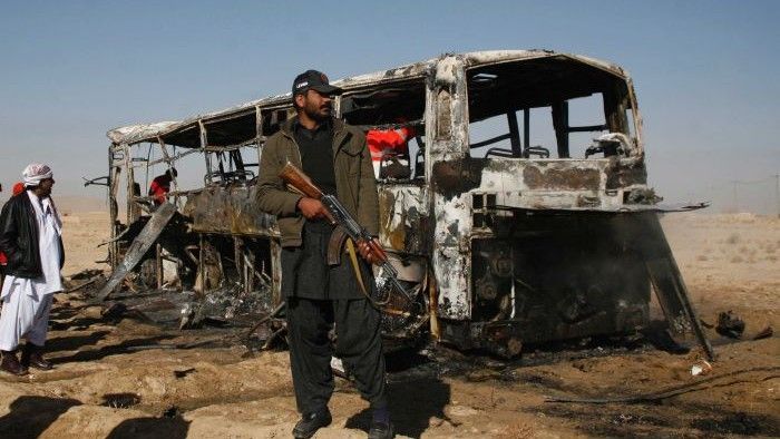 W tle spalony wrak autokaru przewożącego pielgrzymów - fot. Reuters: Naseer Ahmed