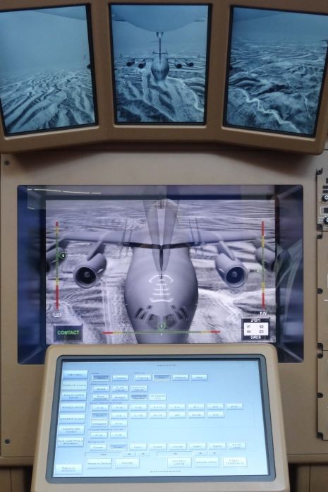 Obraz jaki widzi operator tankowania w locie samolotu Boeing KC-46 Pegasus. Obraz centralnego ekranu wydaje się "rozdwojony" bez okularów 3D. Nad nim panoramiczne ekrany pokazujące obraz od skrzydła do skrzydła. - fot. J.Sabak/D24