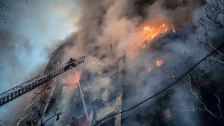 Budynek stojący w ogniu tuż po rosyjskim ataku rakietowym podczas wojny w Ukrainie.