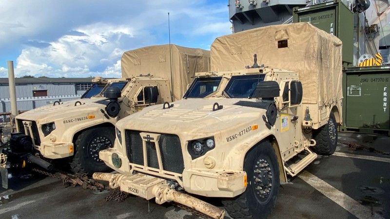 Samochody JLTV M1279 Utility ze skrzyniami ładunkowymi z plandekami.