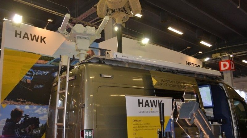 Prezentowana w czasie targów MSPO 2022 mobilna wersja systemu antydronowego Hawk z radarami wstępnego wykrywania i nadajnikami zakłóceń zamontowanymi na pojeździe oraz ustawionym obok ręcznym neutralizatorem