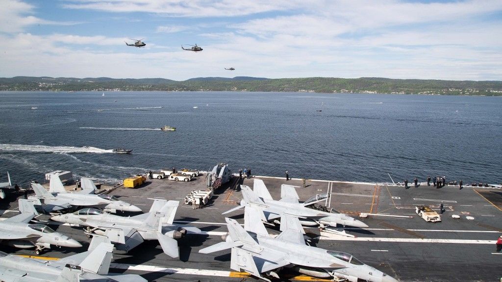 Norweskie śmigłowce wojskowe przelatują w pobliżu lotniskowca USS „Gerald R. Ford”, gdy okręt przepływa przez fiord Oslo 24 maja 2023 r.
