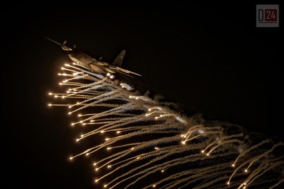 C-130 Hercules Sił Powietrznych w trakcie przelotu podczas pokazów nocnych w sobotę - zrzucający flary