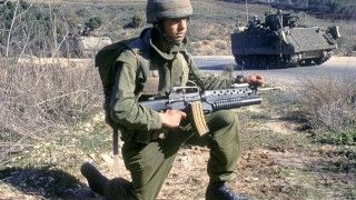 Izraelski żołnierz podczas interwencji wojskowej w Libanie, styczeń 1993 roku. W tle transporter opancerzony M113.
