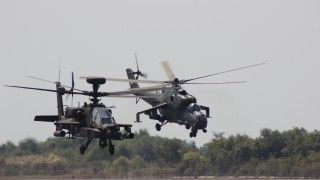 Amerykański śmigłowiec szturmowy AH-64E Apache Guardian w locie z indonezyjskim Mi-35 podczas ćwiczeń Garuda Shield w 2014 roku.