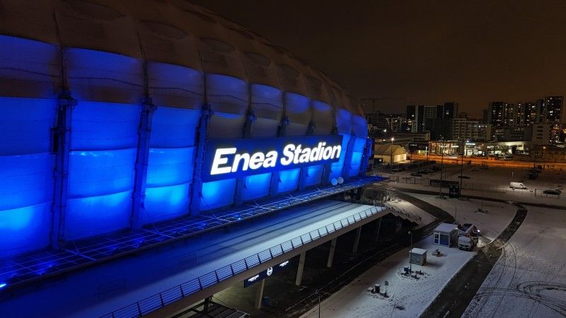 biały napis Enea Stadion na niebieskim tle na zewnętrznej części stadionu w Poznaniu