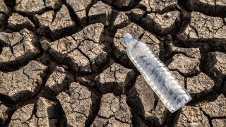 pusta plastikowa butelka po wodzie na wysuszonej ziemi