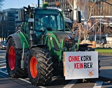 Traktor z wyieszonym z przodu transparentem z napisem ohne korn kein bier – nie ma piwa bez zboża