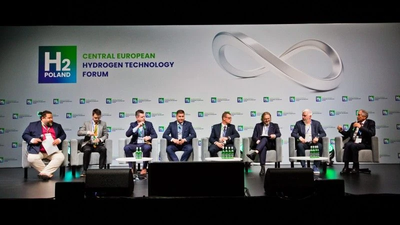 Paneliści na scenie podczas panelu na konferencji
