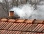 Komin na dachu, z którego wydobywa się dym