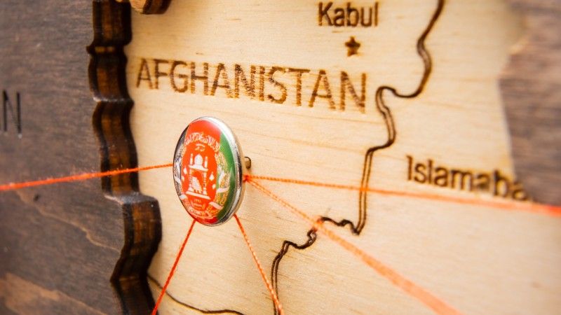 pinezka z flagą Afganistanu wbita w drewnianą mapę regionu
