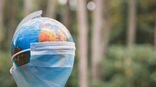 globus przykryty maseczką na tle lasu Garakta-Studio