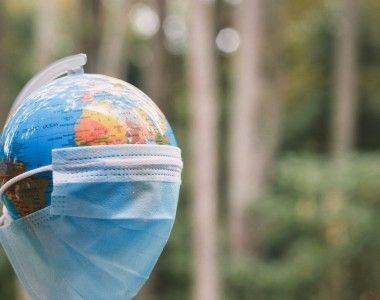 globus przykryty maseczką na tle lasu Garakta-Studio