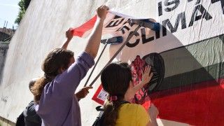 Aktywiści przyklejają plakat na ścianie