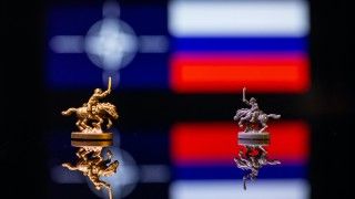figurki żołnierzy na koniach na tle flagi Rosji i flagi NATO