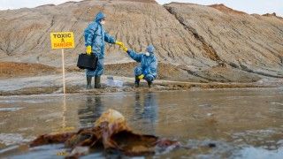 badacze pobierają próbki zanieczyszczonej gleby po wycieku ropy