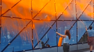 Dwoje aktywistów oblewa szyby Złotych Tarasów pomarańczową farbą ze spryskiwacza