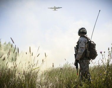 Łotewski żołnierz na ćwiczeniach w Stanach Zjednoczonych w 2014 roku. W tle amerykański samolot transportowy C-130 Hercules.