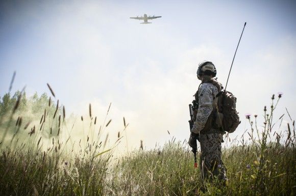 Łotewski żołnierz na ćwiczeniach w Stanach Zjednoczonych w 2014 roku. W tle amerykański samolot transportowy C-130 Hercules.