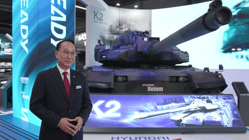 Gen. w st. spocz. dr Eui-Seong Lee, wiceprezes Hyundai Rotem Company ds. międzynarodowych projektów zbrojeniowych, podczas MSPO 2024. W tle demonstrator czołgu podstawowego K2EX.