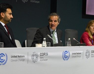 Trzy osoby siedzą za stołem z napisami: United Nations Climate Change, COP29 Baku Azerbaijan