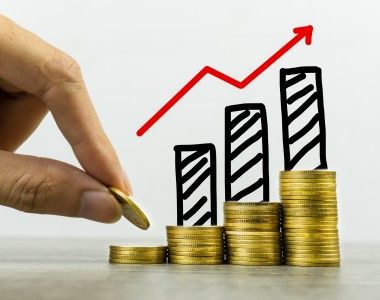 Monety ułożone na tle wykresu symbolizującego wzrost