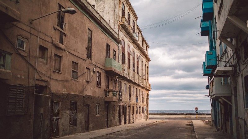 ulica z widokiem na ocean, budynki są zniszczone, okna zabite deskami