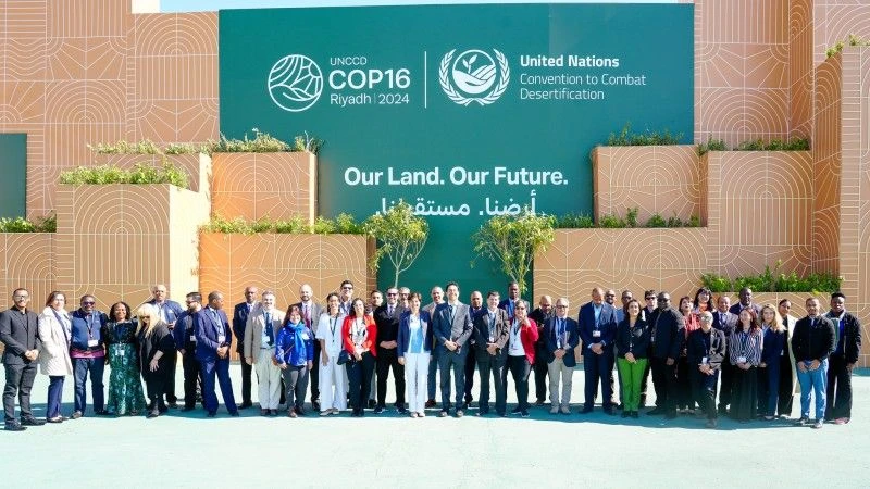 Przedstawiciele państw na tle ścianki z napisem: UNCDD COP16 Riyadh 2024 Our Land Our Future