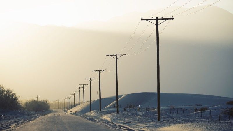 Linie energetyczne przy zaśnieżonej drodze