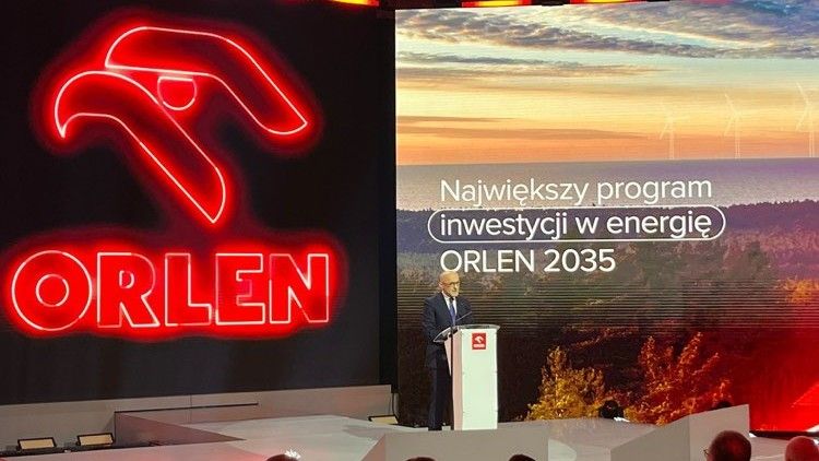 prezes orlenu stoi za mównicą na konferencji. W tle neon z logo orlenu i napis na ekranie: największy program inwestycji w energię orlen 2035