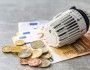 Głowica termostatyczna leży na rozrzuconych banknotach euro
