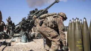 Artylerzyści 25 Dywizji Piechoty U.S. Army prowadzą ogień z haubicy M777 na ćwiczeniach w Iraku, marzec 2020 roku. Po prawej widać paletę z pociskami odłamkowo-burzącymi typu M795.