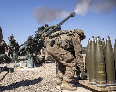 Artylerzyści 25 Dywizji Piechoty U.S. Army prowadzą ogień z haubicy M777 na ćwiczeniach w Iraku, marzec 2020 roku. Po prawej widać paletę z pociskami odłamkowo-burzącymi typu M795.