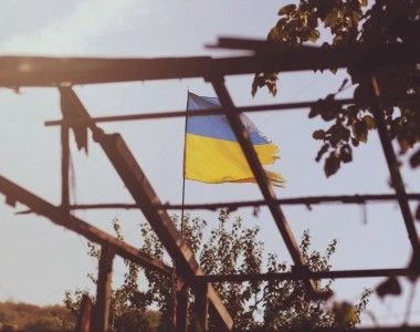 Postrzępiona flaga Ukrainy na tle błękitnego nieba