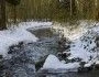 strumień płynący przez las wczesną wiosną, śnieg zaczyna się topić, świeci poranne słońce