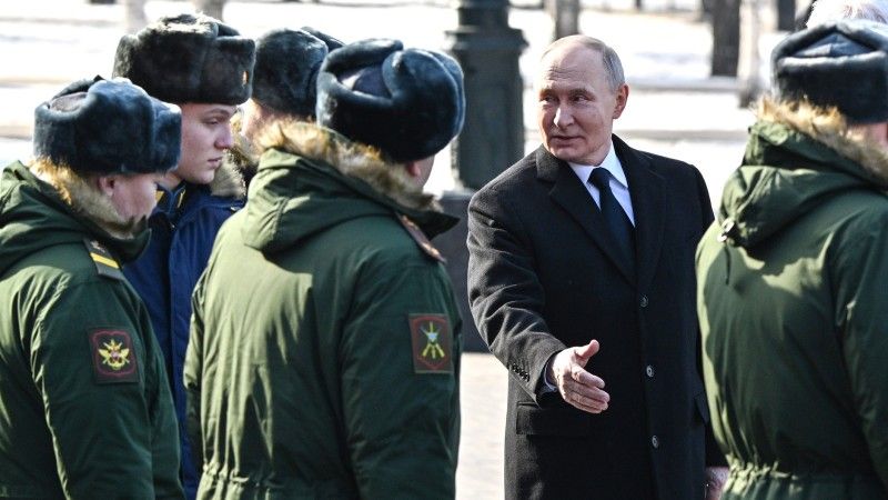 Prezydent Władimir Putin w otoczeniu wojskowych.