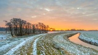Zachód słońca nad strumykiem, oszroni ona trawa i drzewa