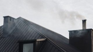 Szary dym unoszący się z komina domu