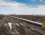 Gazociąg w budowie rozłożony na błotnistej ziemi