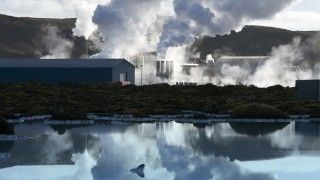 Widok na elektrownię geotermalną, odbijającą się w tafli wody