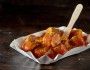 Kawałki kiełbaski currywurst na papierowym talerzyku