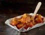 Kawałki kiełbaski currywurst na papierowym talerzyku