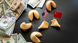 Flagi Chin i USA wbite w ciasteczka z wrożbą, obok leżą dolary