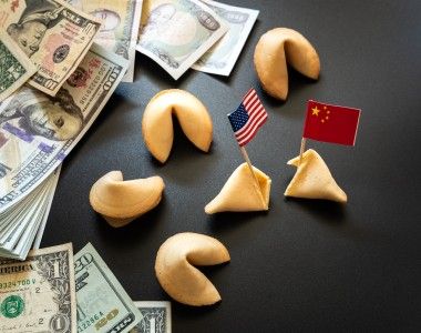 Flagi Chin i USA wbite w ciasteczka z wrożbą, obok leżą dolary