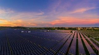 Widok na farmę fotowoltaiczną o zachodzie słońca.